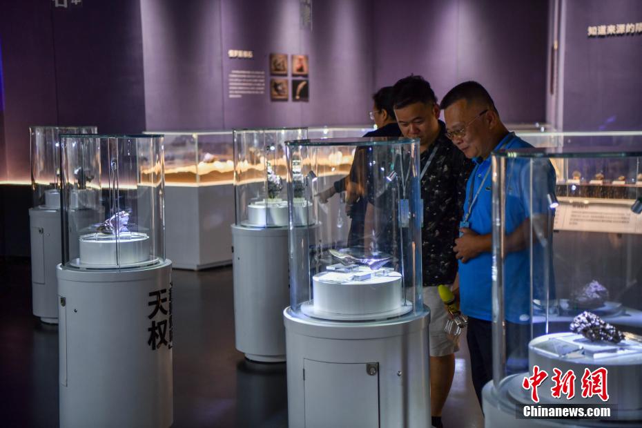 中新社记者 骆云飞 摄 6月10日，展出的陨石标本吸引参观者。当日，海南文昌极星陨石博物馆内游客络绎不绝。该博物馆以“陨石科学+航天探索”为主题，展出400余件珍贵陨石标本，通过陨石标本展示、陨石演化场景及前沿科技手段，让游客近距离感受陨石的奥秘与宇宙的浩瀚。