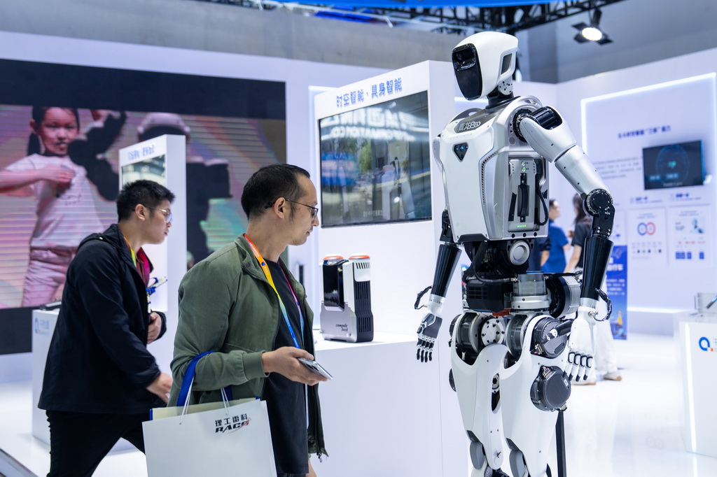 9月24日，在株洲国际会展中心，观众在观看一台人形机器人。 9月24日，第四届北斗规模应用国际峰会在湖南株洲开幕，本届峰会以“同世界·共北斗——智联时空”为主题，除开幕式外，还设置1场高端主旨演讲、5场主题论坛、6场学术交流、1个场景示范展等活动，展示北斗规模应用与经济社会的深度融合。新华社记者 陈思汗 摄