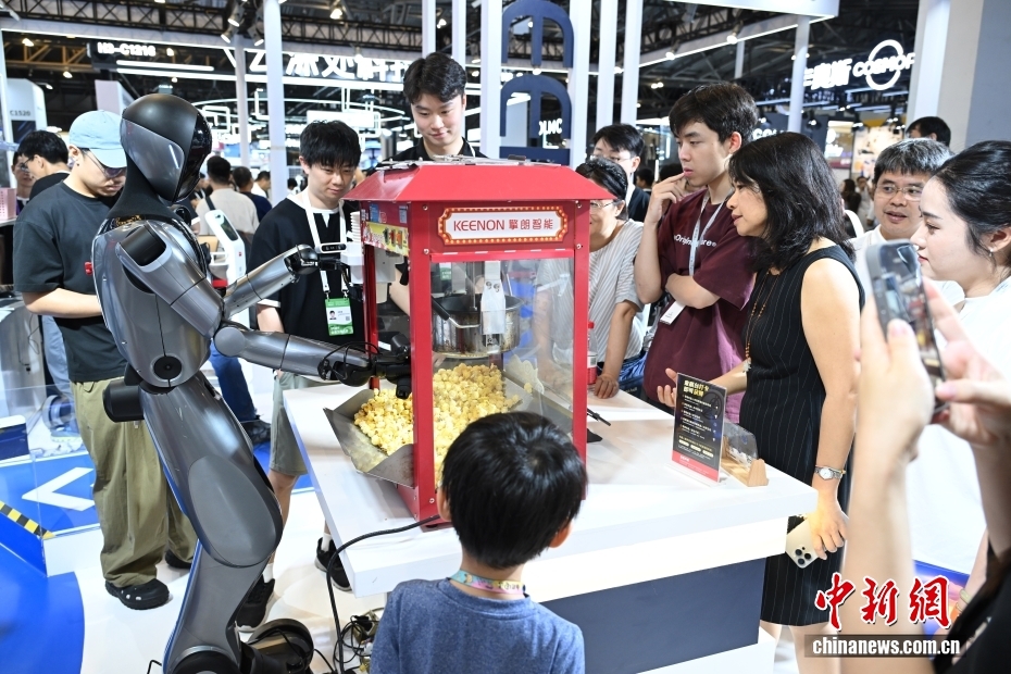 7月26日，卖爆米花的机器人吸引观众。当日，2025世界人工智能大会在上海开幕。大会展览面积首次突破7万平方米，吸引了800余家企业参展，集中展示3000余项前沿展品及100余款“全球首发”“中国首秀”新品，规模创历届之最。 中新社记者 汤彦俊 摄
