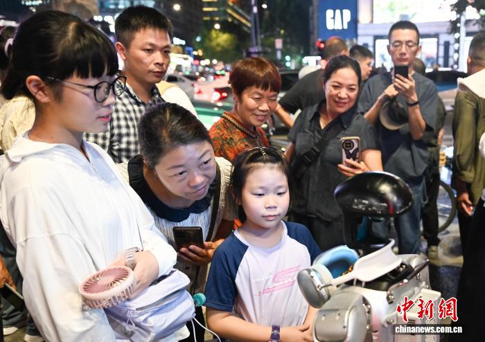 8月19日，行人观看、拍摄人形机器人。中新社记者 王刚 摄