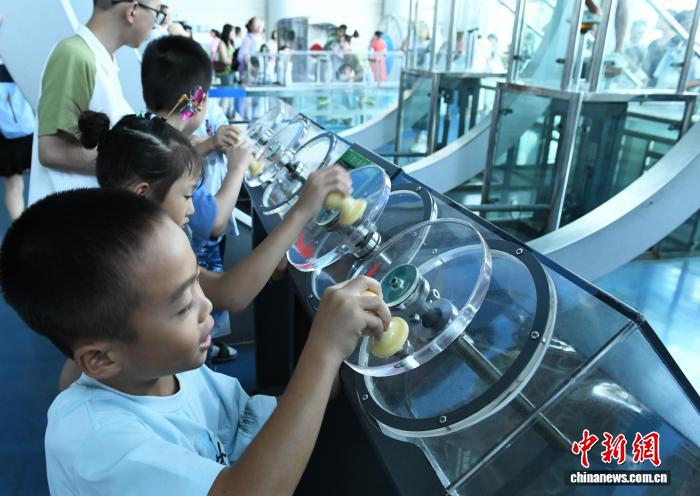 8月21日，正值暑假，重庆科技馆变身儿童乐园，吸引不少市民带着小孩前来参观、游玩，探索科学奥秘。图为小朋友体验不同的船用螺旋桨。中新社记者 周毅 摄