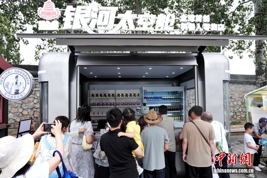 中新社记者 张祥毅 摄 9月13日，位于北京颐和园的一家机器人零售店吸引游客。据了解，该零售店由机器人自主提供接待、点单、支付、取货、交付全流程服务，主营饮料和公园文创产品。