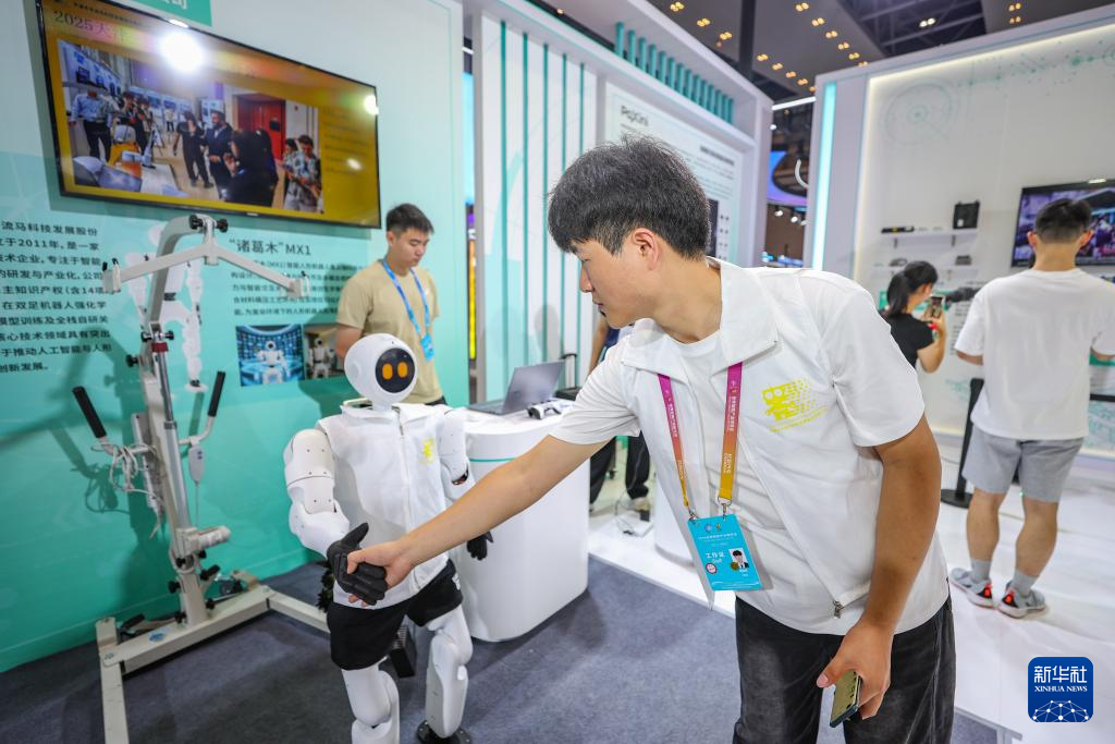 9月5日，在2025世界智能产业博览会现场，参展商和人形机器人互动。 9月5日至8日，2025世界智能产业博览会在重庆举行。众多人形机器人在智博会上亮相，为观众带来不少乐趣。 新华社记者 黄伟 摄pagebreak