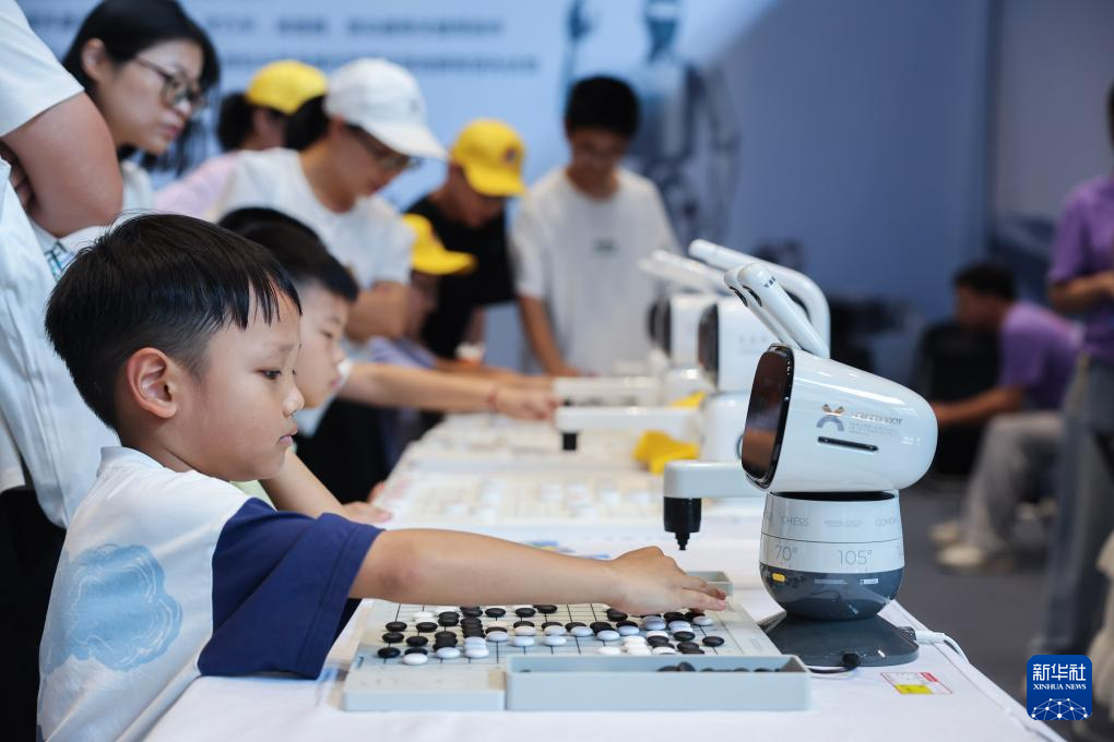 8月17日，小朋友在青少年科技嘉年华上与机器人对弈。 8月15日至25日，首届乌镇青少年科技嘉年华在浙江省桐乡市乌镇举行。这场为期11天的科技盛宴，汇聚4万余名全球青少年科技爱好者，让千年水乡古镇成为连接当下与未来的“科技体验场”。 作为世界互联网大会永久举办地，乌镇此次联动互联网之光博览中心、互联网国际会展中心、世界互联网科技馆三大场馆，打造青少年科技嘉年华，推出“赛、学、玩”三大板块，通过举办全国青少年劳动技能与智能设计大赛、全国青少年信息素养大赛、全国青少年人工智能创新挑战赛，打造沉浸式体验的“未来实验室”，开设“全球科技灵感市集”等，为青少年搭建起展示智慧、激发创新、触摸未来的综合平台。 新华社记者 徐昱 摄