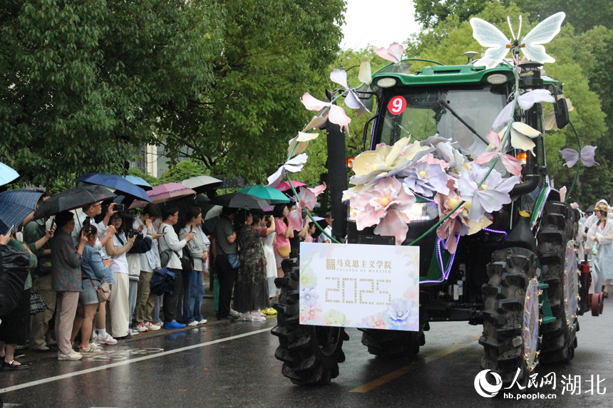 6月21日下午，华中农业大学举行2025年毕业巡游。16台现代农机装备组成的“钢铁长龙”在雨中浩荡启程，收割机、播种机、拖拉机等变身“花车”巡游校园，为毕业生铺就一条别开生面的青春征途。人民网记者 张沛摄影报道
