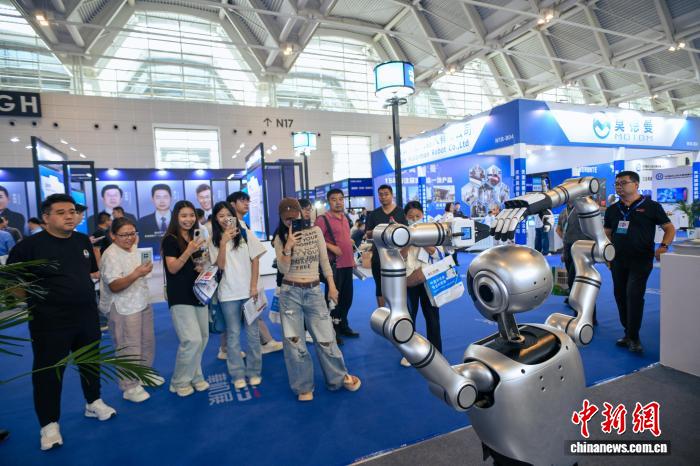 图为人形机器人通过“比心”手势与观众互动。中新社记者 佟郁 摄