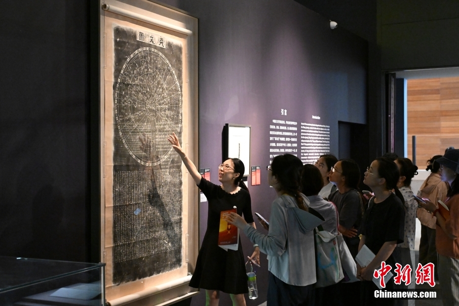 7月2日，由中国国家博物馆、瑞士驻华大使馆、瑞士洛桑联邦理工学院主办，清华大学天文系、清华大学美术学院协办的“宇宙考古：时空探索”展览在北京中国国家博物馆开展。展览分为“仪器和技术：绘制宇宙”“大数据的星空”“可持续的太空”“未来：行星之旅”四个部分，融科学探索和艺术诠释为一体，将宇宙中真实、分散、抽象的数据，通过数字装置、互动体验、动态雕塑和前瞻性设计等多种形式呈现出来。图为工作人员为观众讲解展出的《南宋天文图碑拓片》，现代天文学家通过计算机比对，确定其星位于现代星表高度吻合。 中新社记者 田雨昊 摄