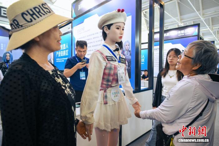 图为人形机器人与参观者互动。中新社记者 佟郁 摄