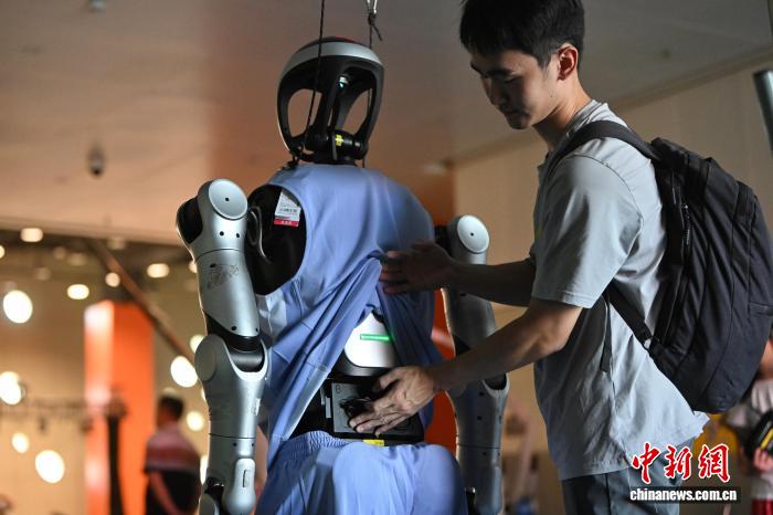 8月24日，第二十七届中国机器人及人工智能大赛人形机器人专项赛全国决赛在安徽省合肥市开赛，该赛事也是中国首个全尺寸人形机器人赛事。比赛吸引了中国近400所高校的6000余名学生参与。赛题紧密围绕工业、家庭服务等真实场景需求，推动人形机器人在多场景中的技术验证与应用突破。图为参赛队员为全尺寸人形机器人调试电池。中新社记者 韩苏原 摄