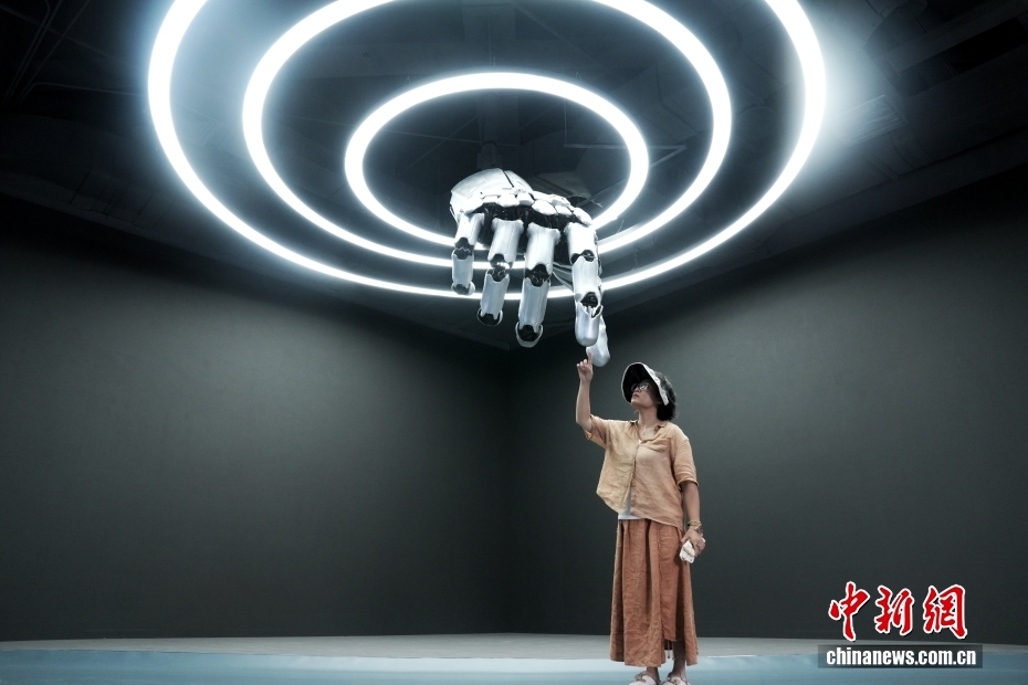 中新社记者 张祥毅 摄 8月4日，在位于北京亦庄的全球首家具身智能机器人4S店Robot Mall，参观者与机械手互动。据了解，该机器人4S店提供机器人展示、体验、销售、售后等服务，进一步完善机器人产业链发展。在2025世界机器人大会期间，该4S店将作为重要的产业服务创新成果亮相。