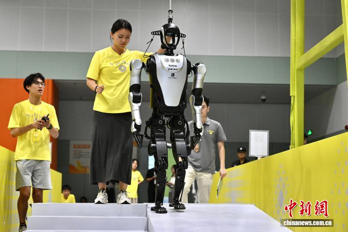 8月24日，第二十七届中国机器人及人工智能大赛人形机器人专项赛全国决赛在安徽省合肥市开赛，该赛事也是中国首个全尺寸人形机器人赛事。比赛吸引了中国近400所高校的6000余名学生参与。赛题紧密围绕工业、家庭服务等真实场景需求，推动人形机器人在多场景中的技术验证与应用突破。图为全尺寸人形机器人正在进行多地形自主通行比赛。中新社记者 韩苏原 摄