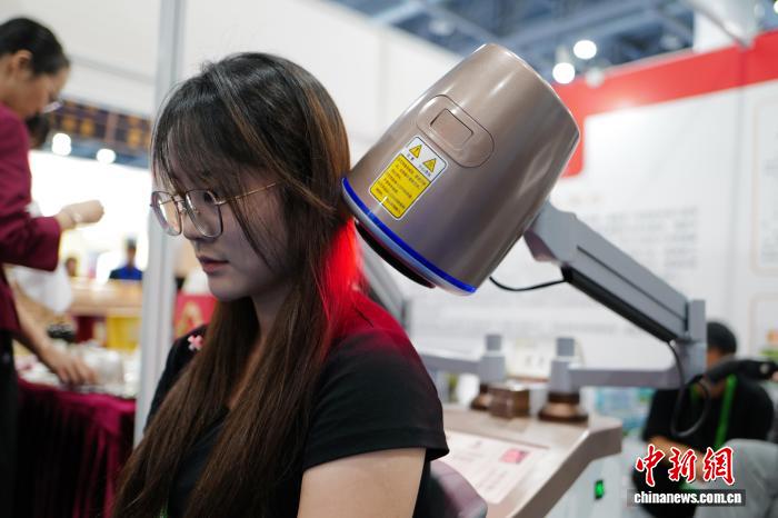 9月10日，民众体验艾灸仪。当日，由中国中医药科技发展中心主办的中医药科技成果交流会暨中医药创新成果展览会在浙江杭州举办，展览展出了一系列便民惠民的中医药健康产品、服务，呈现中医药深厚底蕴与现代技术的结合。中新社记者 张煜欢 摄