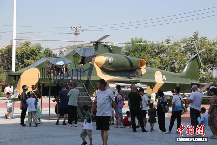 图为观众排队体验参观武直-10直升机内部。甘肃科技馆供图