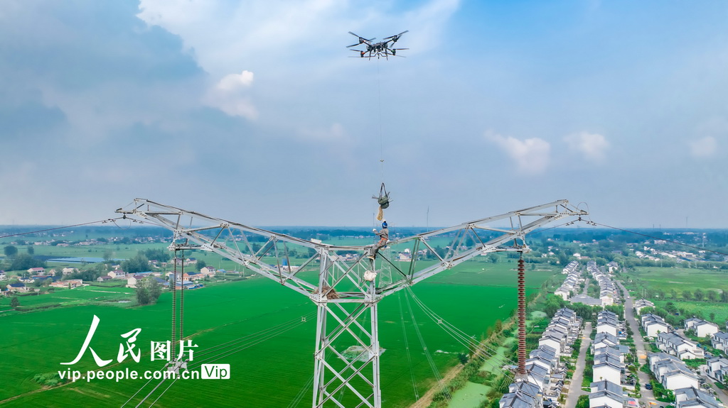 江苏淮安：无人机助力电网不停电检修【4】 8月6日，在江苏省淮安市500千伏旗潘/杰潘输电线路施工现场，电力工人运用中型多旋翼无人机进行不停电安装防鸟装置作业。该技术通过无人机精准投放防鸟装置，显著提升了作业效率和安全性，避免了传统停电作业对居民和企业用电的影响，为夏季用电高峰期间电网安全稳定运行提供了有力保障。史俊摄（人民图片网）