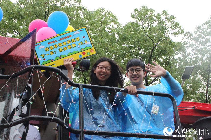 6月21日下午，华中农业大学举行2025年毕业巡游。16台现代农机装备组成的“钢铁长龙”在雨中浩荡启程，收割机、播种机、拖拉机等变身“花车”巡游校园，为毕业生铺就一条别开生面的青春征途。人民网记者 张沛摄影报道