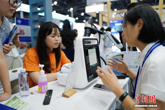 9月10日，民众体验中医经络信息采集系统，工作人员为其进行数据分析。当日，由中国中医药科技发展中心主办的中医药科技成果交流会暨中医药创新成果展览会在浙江杭州举办，展览展出了一系列便民惠民的中医药健康产品、服务，呈现中医药深厚底蕴与现代技术的结合。中新社记者 张煜欢 摄