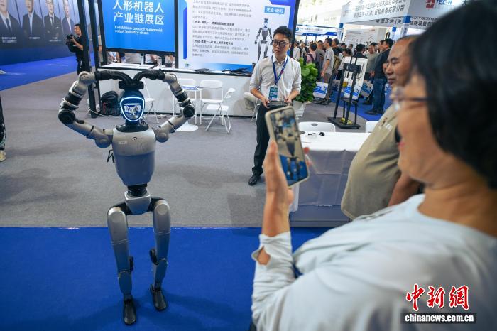 图为人形机器人通过“比心”手势与观众互动。中新社记者 佟郁 摄