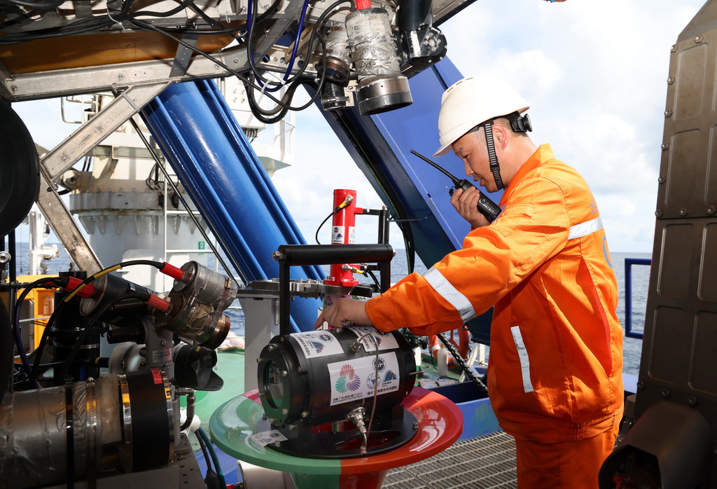 下水采集“源火”前，工作人员在调整搭载在“海马”号深海遥控潜水器上的采火装置（9月18日摄）。 10月9日，第十五届全国运动会、全国第十二届残疾人运动会暨第九届特殊奥林匹克运动会火种采集仪式在广州举行。全运圣火“源火”来自南海1500多米深海底，通过引燃可燃冰的方式获取。 9月18日，在南海北部海域，我国自主研发的“海马”号深海遥控潜水器（ROV）搭载“可燃冰原位采集分解及引燃装置”下潜到1500多米深海底，科研人员远程操控采集可燃冰，并降压使其分解，产生的甲烷气体即为“源火”气源。随后，科考船甲板面的太阳能光伏装置发电并传输到海底，引燃气源获取“源火”。“海马”号携带燃烧的“源火”返回科考船甲板面后，科研人员将“源火”转移至“源火”盒，“源火”采集成功。新华社记者 卢汉欣 摄