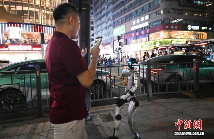 8月19日，人形机器人在街头倒走。中新社记者 王刚 摄
