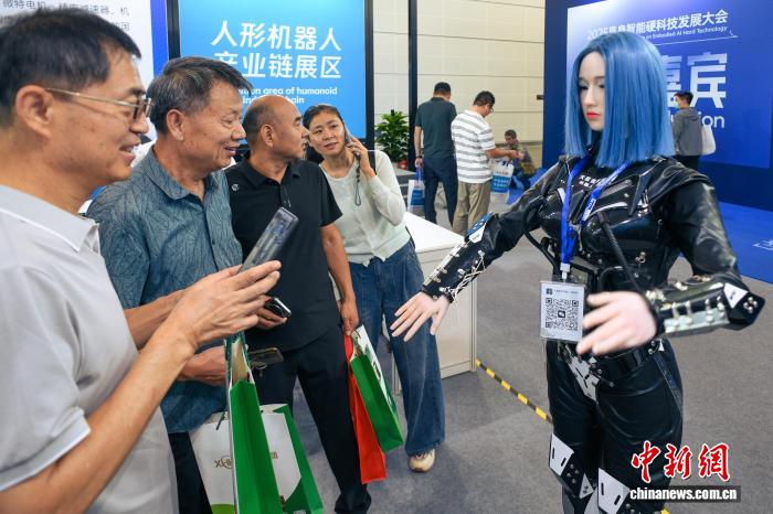 图为人形机器人与参观者互动。中新社记者 佟郁 摄