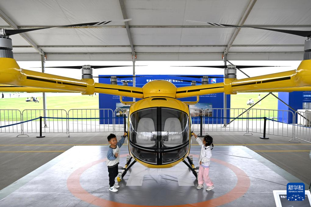 9月21日，小朋友在“全空间无人体系成果展”上参观一款无人驾驶电动垂直起降航空器。 新华社记者 黄博涵 摄pagebreak