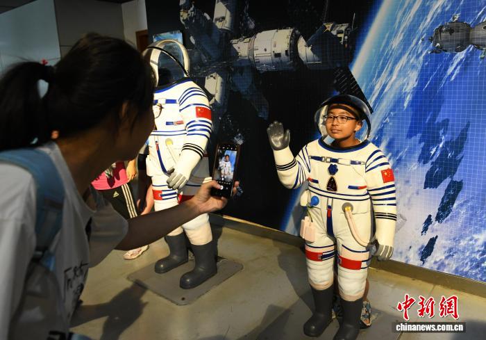 8月21日，正值暑假，重庆科技馆变身儿童乐园，吸引不少市民带着小孩前来参观、游玩，探索科学奥秘。图为市民在宇航科技厅参观拍照。中新社记者 周毅 摄