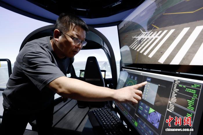 9月4日，工程师在模拟机上进行设备调试。近日，上海沃兰特航空技术有限责任公司电动垂直起降航空器（eVTOL）VE25工程模拟机正式开启试飞员训练。这台专业级工程模拟机是国内首台专业级eVTOL工程模拟机，将为eVTOL的工程试验、适航验证、飞行训练等全产业链发展积累宝贵。中新社记者 殷立勤 摄