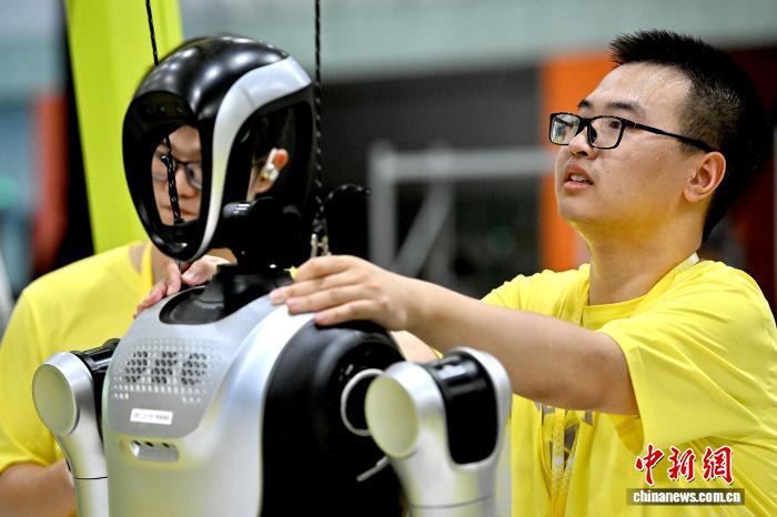 8月24日，第二十七届中国机器人及人工智能大赛人形机器人专项赛全国决赛在安徽省合肥市开赛，该赛事也是中国首个全尺寸人形机器人赛事。比赛吸引了中国近400所高校的6000余名学生参与。赛题紧密围绕工业、家庭服务等真实场景需求，推动人形机器人在多场景中的技术验证与应用突破。图为参赛队员正在调试全尺寸人形机器人。中新社记者 韩苏原 摄