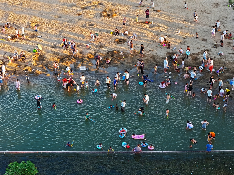 游客在海边消暑 乐享清凉夏日