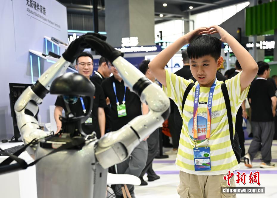 中新社记者 王刚 摄 9月24日，机器人模仿参观者的动作。当日，2025云栖大会在浙江杭州开幕，大会以“云智一体·碳硅共生”为主题，500余家企业的大模型、具身智能等3500多件产品集中亮相，全景呈现AI的技术演进与产业落地。