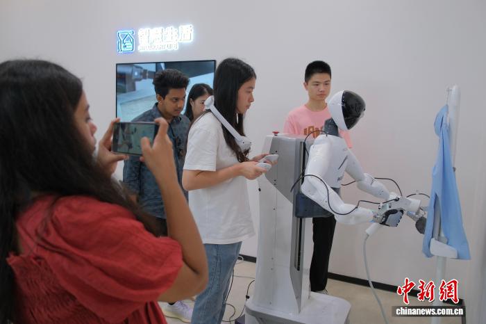 7月31日，游客在数据采集机器人前拍照。中新网记者 曹丹 摄