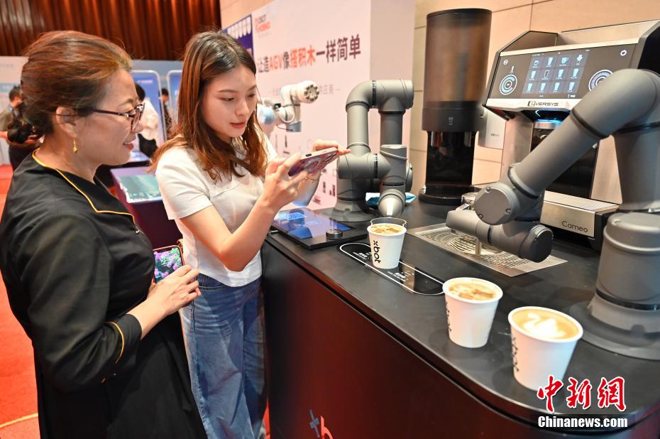 中新社记者 陈楚红 摄 5月21日，2025全球智能机器人发展大会在广东省广州白云国际会议中心开幕。大会以“遇见未来，拥抱智能”为主题，汇聚全球顶尖行业领袖、权威学者及创新企业代表，深入探讨人工智能在智能制造、工作生活、服务消费等领域的潜力与挑战。图为咖啡机器人制作咖啡，吸引参观者。