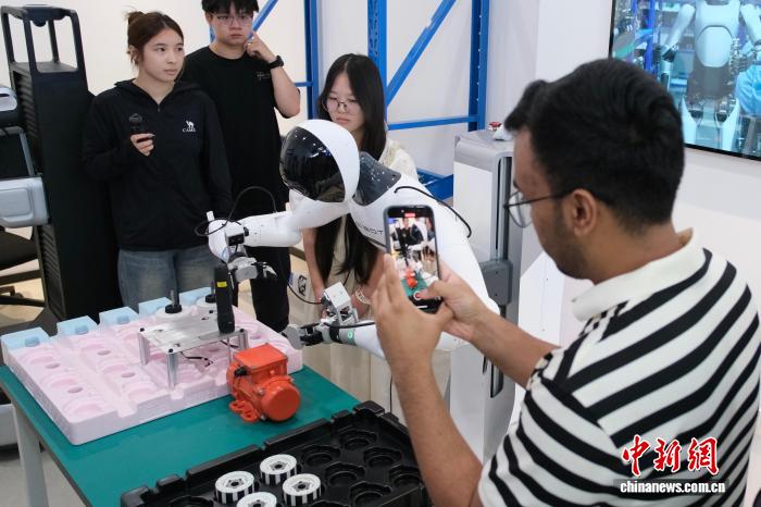 7月31日，游客在数据采集机器人前拍照。中新网记者 曹丹 摄