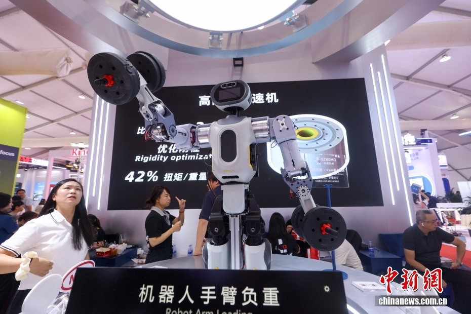 中新社记者 贾天勇 摄 8月11日，2025世界机器人大会继续在北京亦庄举行，展出的各类机器人刮起运动旋风。图为机器人展示“举重”。