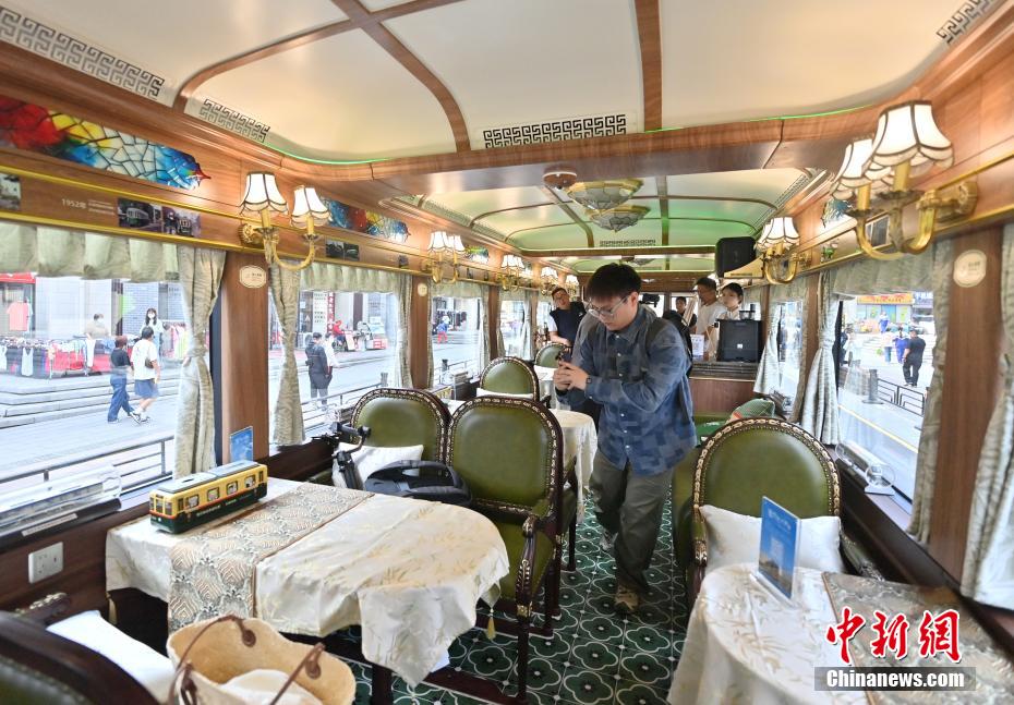 中新社记者 张瑶 摄 6月4日，吉林长春，市民在氢能源文旅专列内拍照留念。该专列由中车长客研制，以历史文化街区新民大街建筑群为设计灵感，车内君子兰花海主题内饰与复古留声机相映成趣。列车采用三级安全防护氢能系统，单次加氢续航320公里。
