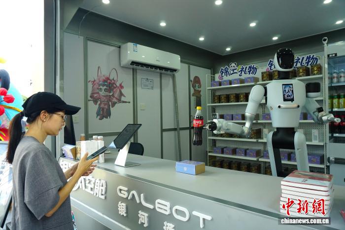 图为店内商品服务机器人将饮料交付顾客。陈选斌 摄
