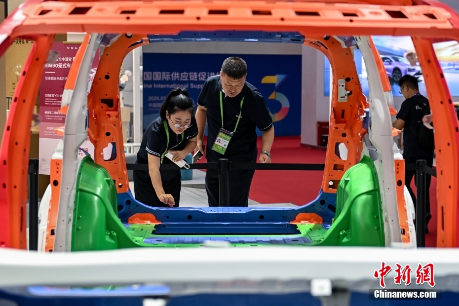 中新网记者 李骏 摄 图为智能汽车链展区，观众在了解车身结构。