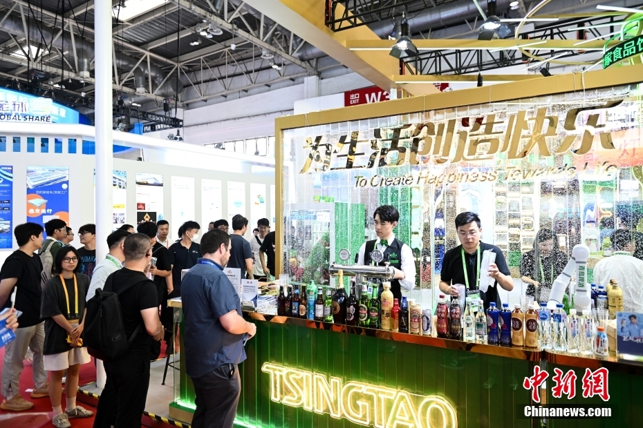 中新网记者 李骏 摄 图为观众在绿色农业链展区排队品尝特色饮品。