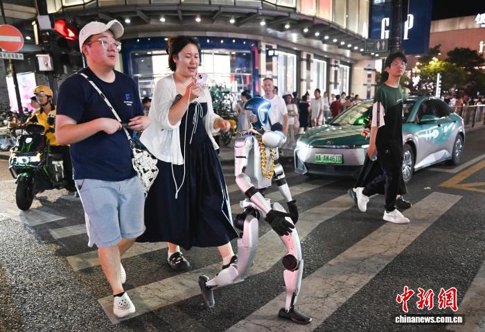 8月19日，人形机器人通过斑马线。中新社记者 王刚 摄