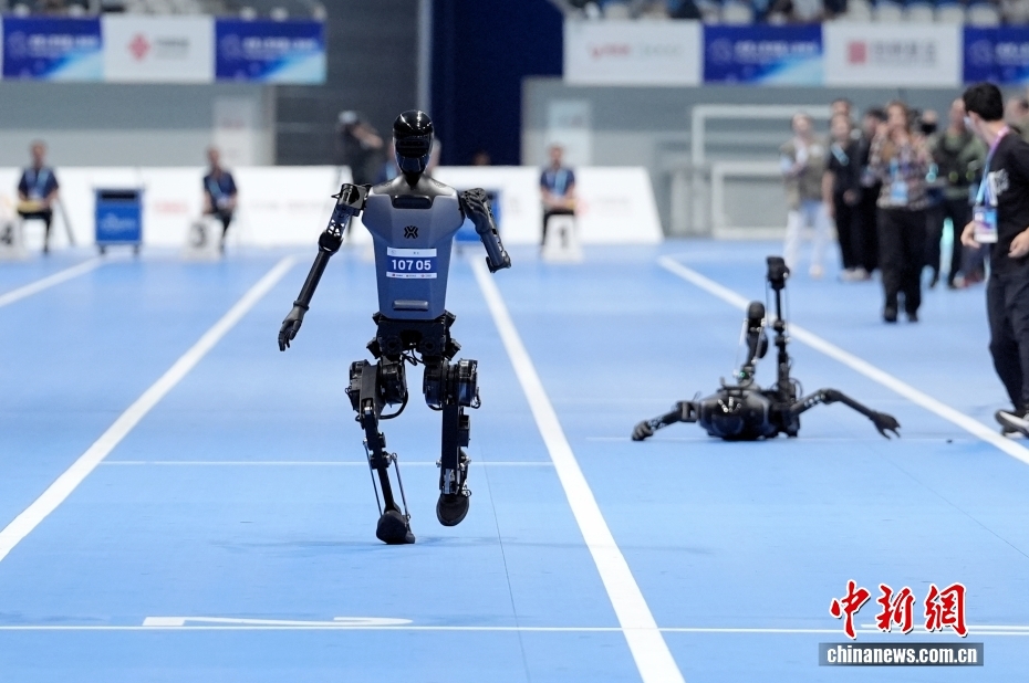 中新社记者 张祥毅 摄 8月17日，2025世界人形机器人运动会100米决赛在北京国家速滑馆（冰丝带）举行，以AI自主操控的天工机器人以21秒50的成绩获本次比赛冠军。图为天工机器人在冲刺中。
