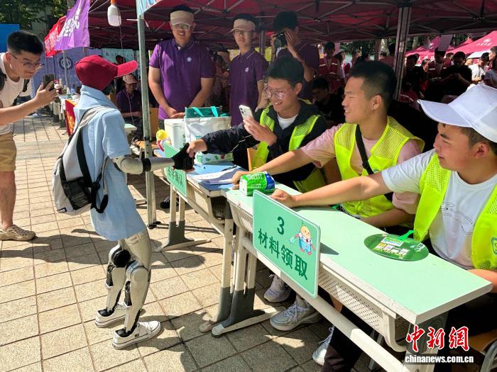 迎新学生与人形机器人握手互动。高艺芯 摄