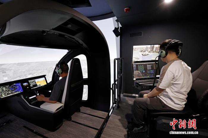 9月4日，工程师在模拟机上进行设备调试。近日，上海沃兰特航空技术有限责任公司电动垂直起降航空器（eVTOL）VE25工程模拟机正式开启试飞员训练。这台专业级工程模拟机是国内首台专业级eVTOL工程模拟机，将为eVTOL的工程试验、适航验证、飞行训练等全产业链发展积累宝贵。中新社记者 殷立勤 摄