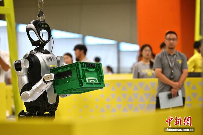 8月24日，第二十七届中国机器人及人工智能大赛人形机器人专项赛全国决赛在安徽省合肥市开赛，该赛事也是中国首个全尺寸人形机器人赛事。比赛吸引了中国近400所高校的6000余名学生参与。赛题紧密围绕工业、家庭服务等真实场景需求，推动人形机器人在多场景中的技术验证与应用突破。图为全尺寸人形机器人正在进行搬运比赛。中新社记者 韩苏原 摄