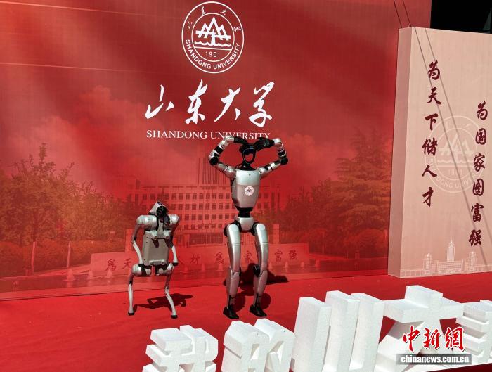 在山东大学中心校区，人形机器人“比心”，与新生互动。高艺芯 摄