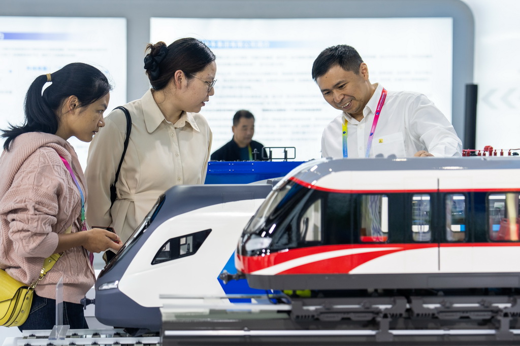 9月24日，在株洲国际会展中心，工作人员（右一）在介绍国产动车组列车。 9月24日，第四届北斗规模应用国际峰会在湖南株洲开幕，本届峰会以“同世界·共北斗——智联时空”为主题，除开幕式外，还设置1场高端主旨演讲、5场主题论坛、6场学术交流、1个场景示范展等活动，展示北斗规模应用与经济社会的深度融合。新华社记者 陈思汗 摄