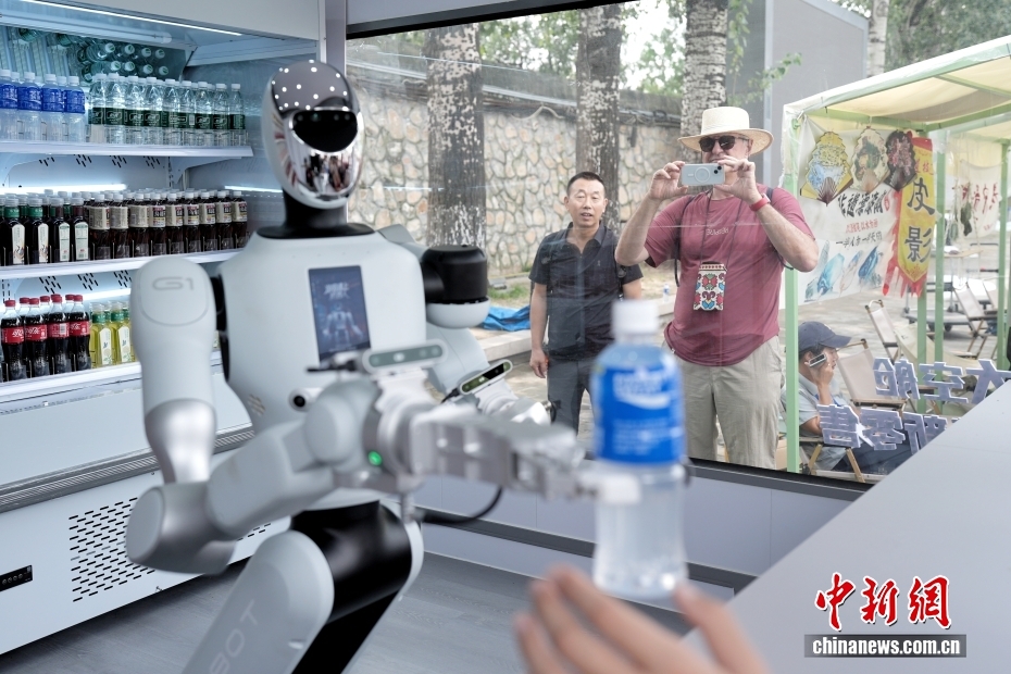 中新社记者 张祥毅 摄 9月13日，位于北京颐和园的一家机器人零售店吸引中外游客。据了解，该零售店由机器人自主提供接待、点单、支付、取货、交付全流程服务，主营饮料和公园文创产品。