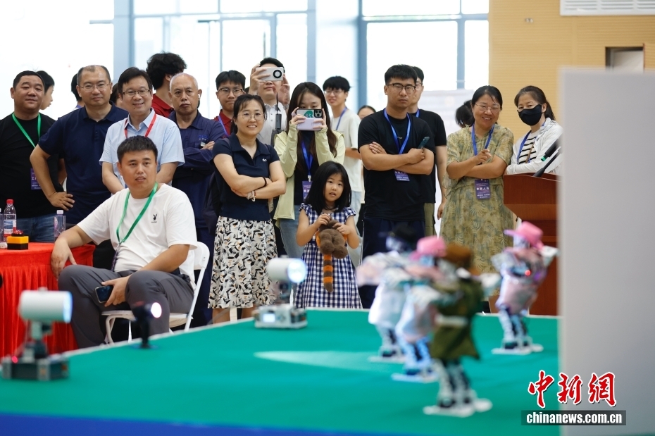 中新社记者 韩海丹 摄 8月2日，2025年华北五省（市、自治区）大学生机器人大赛舞蹈专项赛在北京信息科技大学举行。作为2025世界人形机器人运动会外围赛集体舞蹈赛的预选赛，本次大赛共有19所高校、32支队伍、176名师生参加。图为场下观众观看机器人舞蹈。