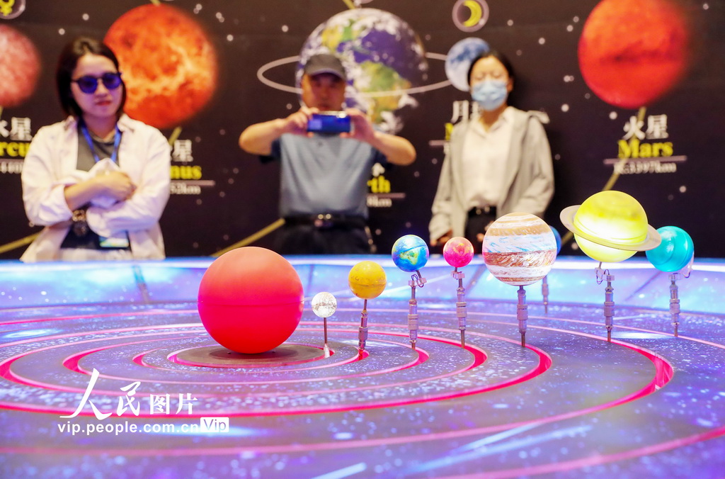 6月7日，游客在甘肃省武威市民勤县摘星小镇的星空探索区学习天文知识。在腾格里沙漠腹地民南公路23公里处，坐落着全国首个沙漠天文科普特色小镇——摘星小镇。该项目占地530亩，由国家天文台提供天文技术支持。小镇以沙漠观星为核心，巧妙融合28星宿与银河概念，打造“太空基地”式布局，分为星空探索区、活动休闲区、游客体验区。游客可在此浩瀚沙海中零距离感受宇宙魅力。张进刚摄（人民图片网）