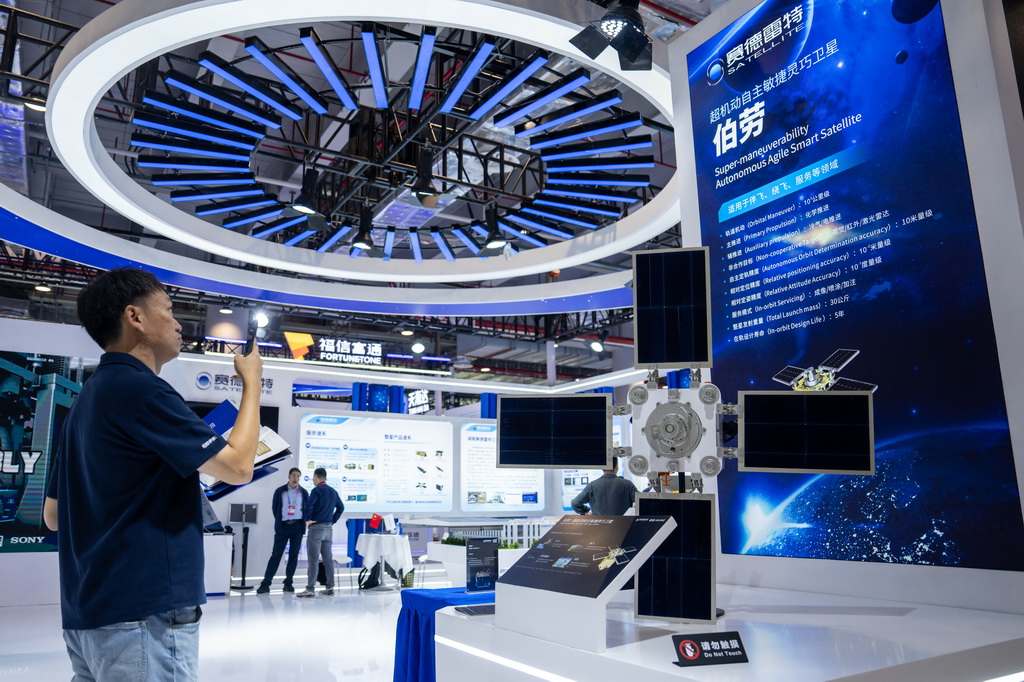 9月24日，在株洲国际会展中心，观众在了解一台小型人造卫星。 9月24日，第四届北斗规模应用国际峰会在湖南株洲开幕，本届峰会以“同世界·共北斗——智联时空”为主题，除开幕式外，还设置1场高端主旨演讲、5场主题论坛、6场学术交流、1个场景示范展等活动，展示北斗规模应用与经济社会的深度融合。新华社记者 陈思汗 摄
