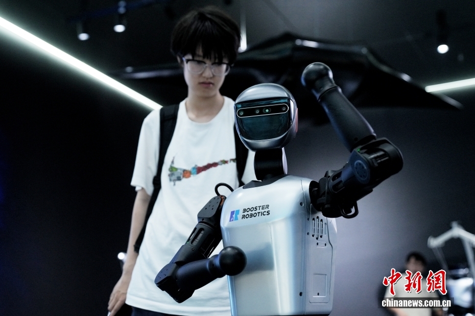 中新社记者 张祥毅 摄 8月4日，在位于北京亦庄的全球首家具身智能机器人4S店Robot Mall，人形机器人吸引参观者。据了解，该机器人4S店提供机器人展示、体验、销售、售后等服务，进一步完善机器人产业链发展。在2025世界机器人大会期间，该4S店将作为重要的产业服务创新成果亮相。